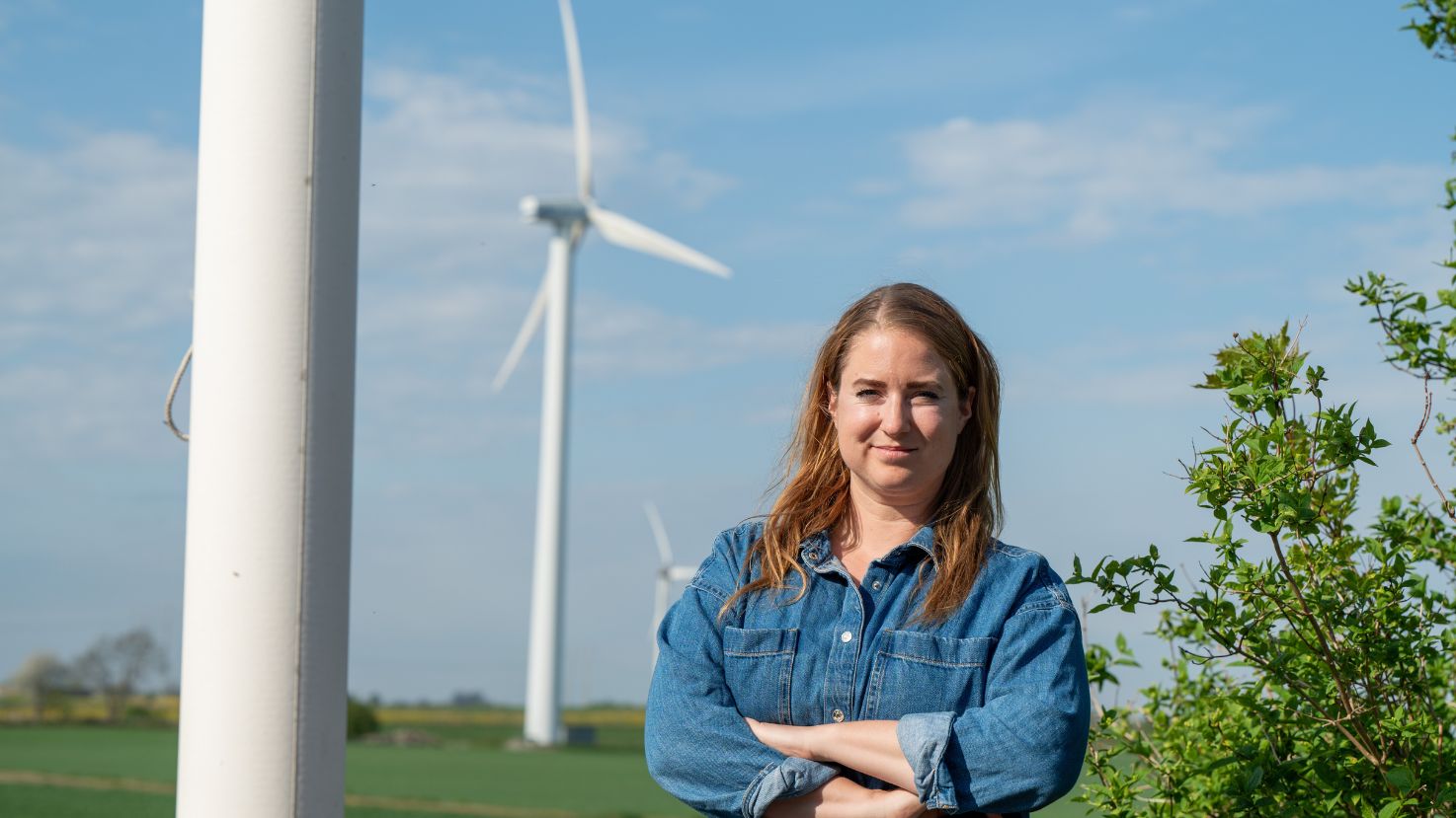 Emma Wiesner, Centerpartiets toppkandidat till EU-valet 2024, står vid vindkraftverk.