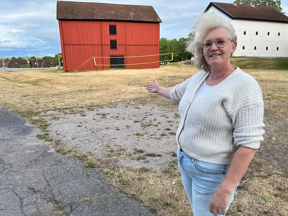 Ulrica står utefter vägen. Bakom syns de två magasinsbyggnaderna.