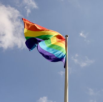 Prideflaggan i regnbågens färger mot himmel