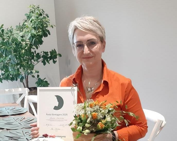 En kvinna med diplom och blommor .