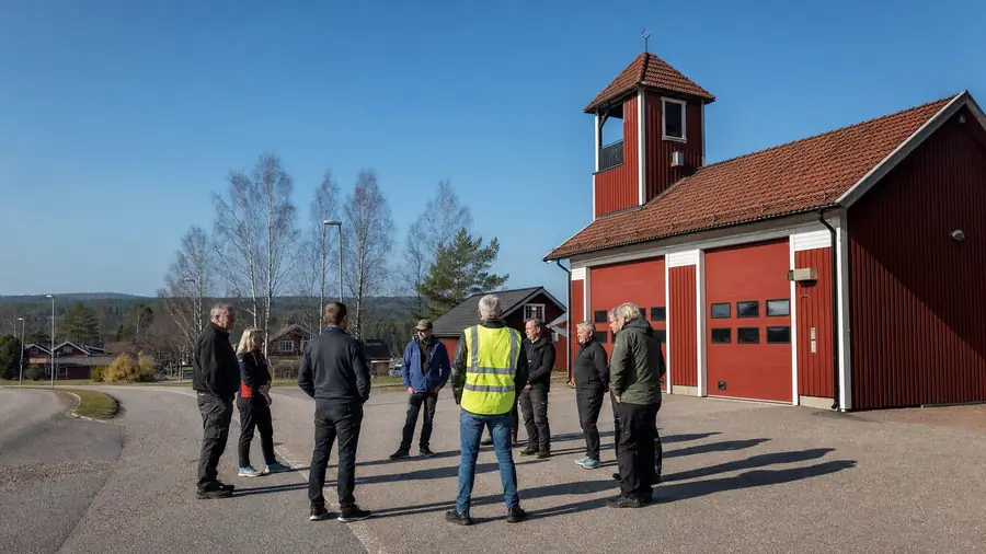 Representanter för civilsamhÀlle och beredskapsfunktioner i samtal framför en röd rÀddningsstation i Mora.