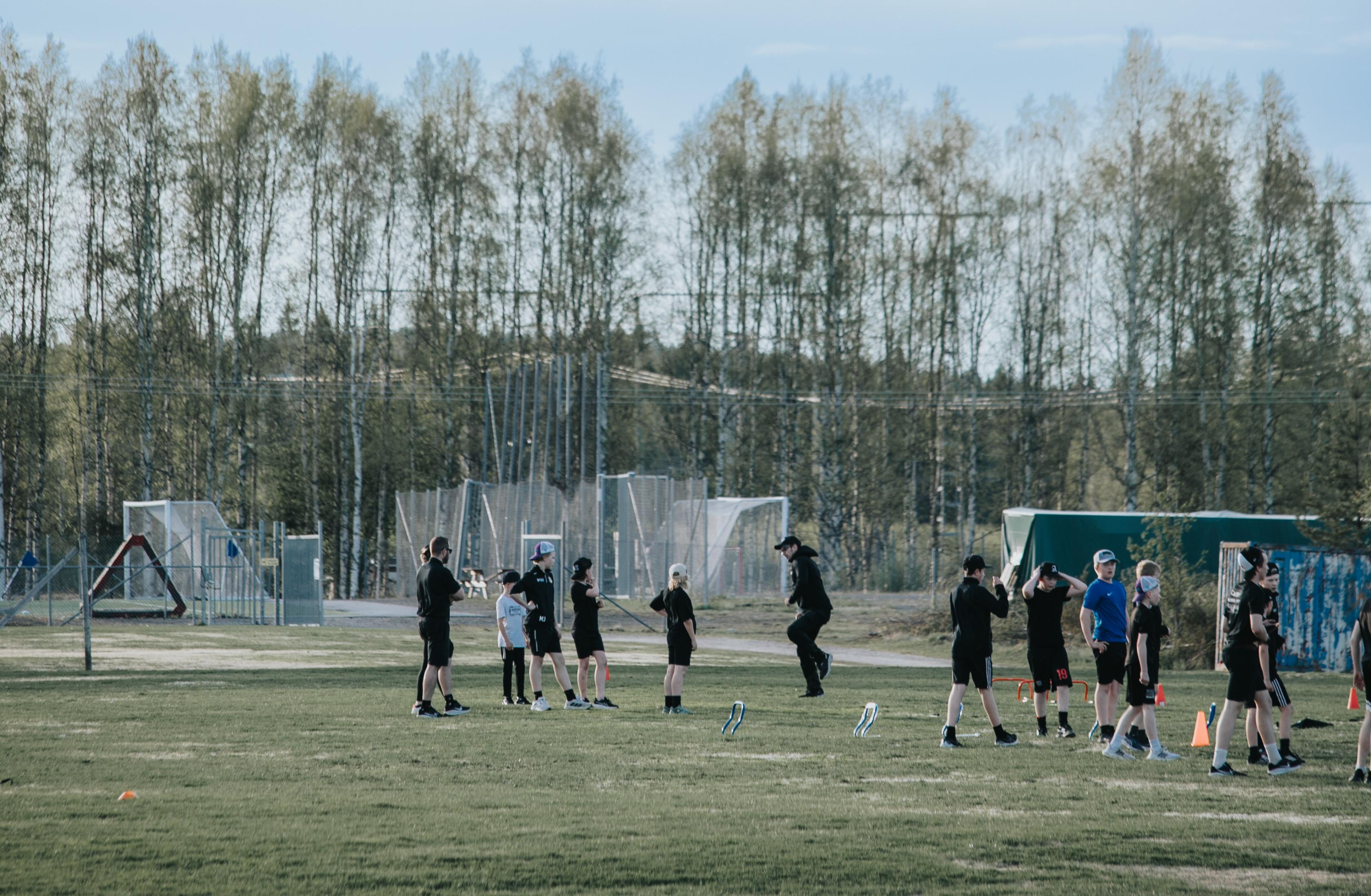 Ett gäng idrottande fotbollsungdomar på gräsplan.