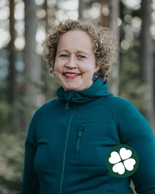 Hanna Lundberg leende i profil med tallar i bakgrunden och Centerklövern nere till höger i bild.