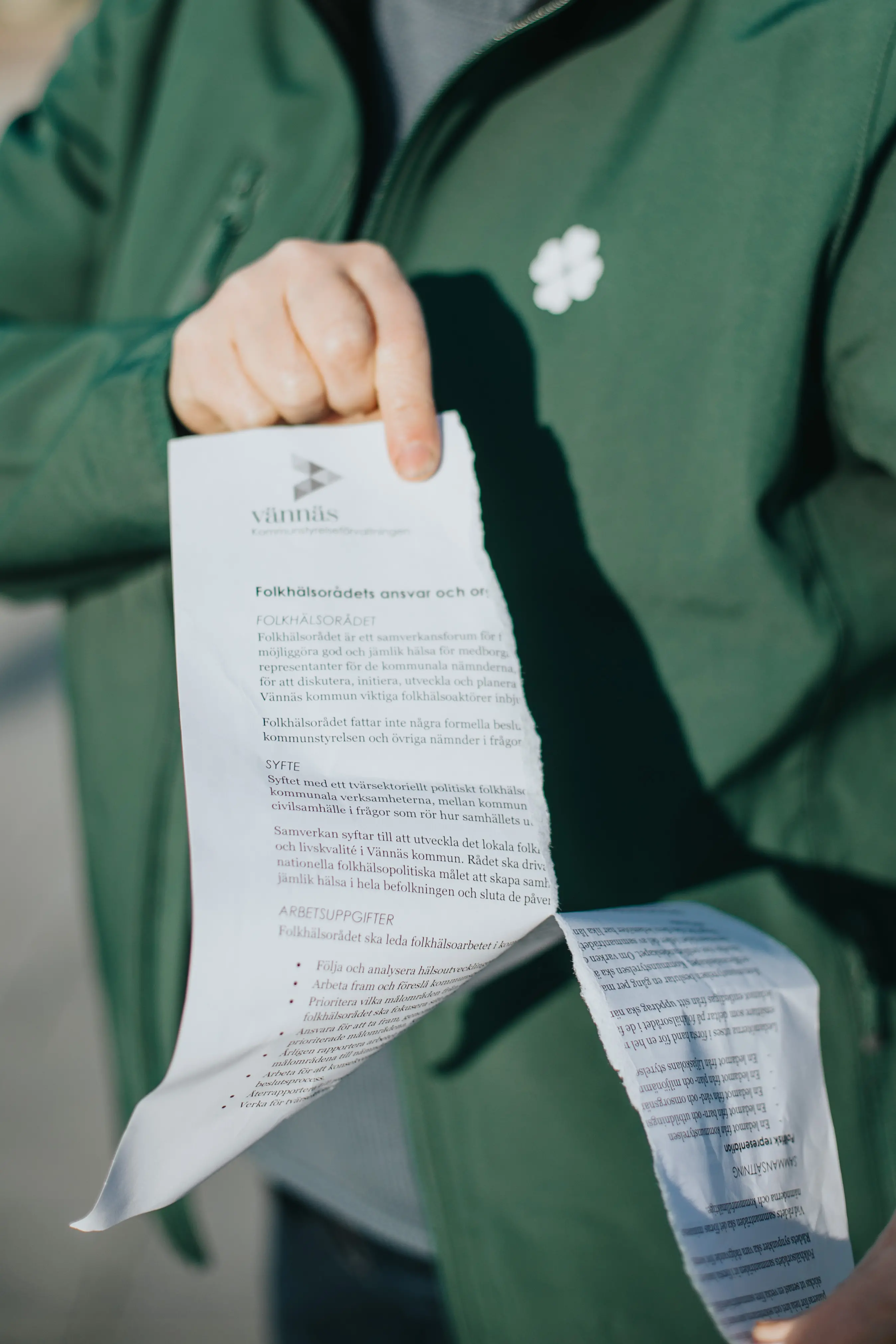 Viktiga papper med en krånglig text rivs av en Centerpartist klädd i gråna profilkläder.