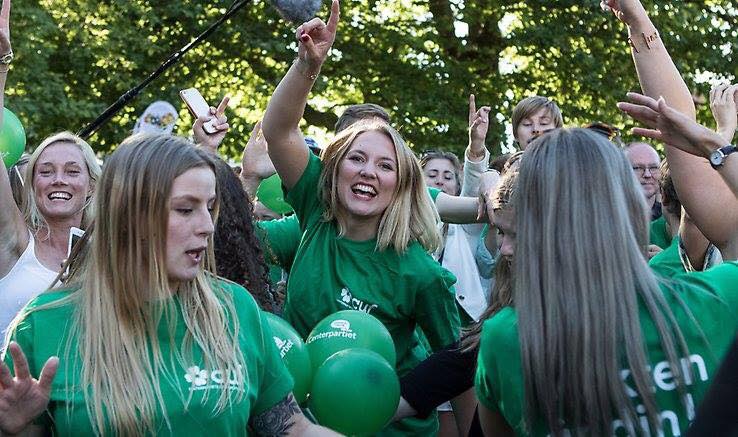 Ett gäng glada ungdomar i gröna tröjor.