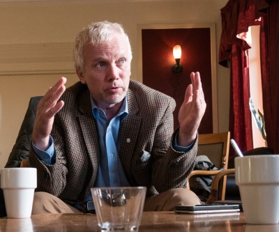 Bild på Lars Kallsäby, sittandes vid ett bord under en mötesdiskussion.