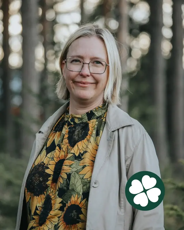 Elisabeth Mach i profil med tallar i bakgrunden och Centerklöver nere till höger i bild.