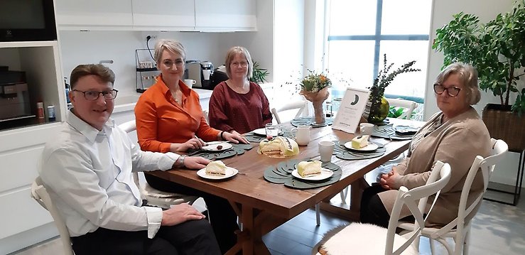 Runt ett köksbord sitter tre kvinnor och en man.