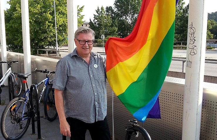 Tage Gripenstam, gruppledare för Centerpartiet i Södertälje vid Prideflaggan utanför Stadshuset