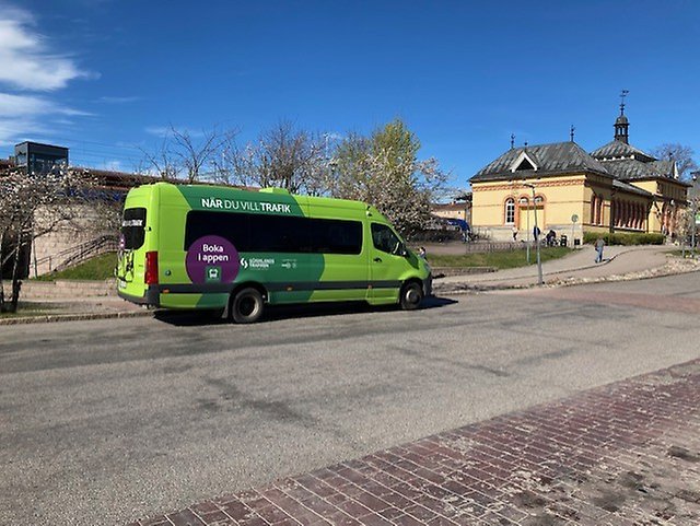 En mindre buss i glada färger. Bilden tagen vid järnvägsstationen i Flen.