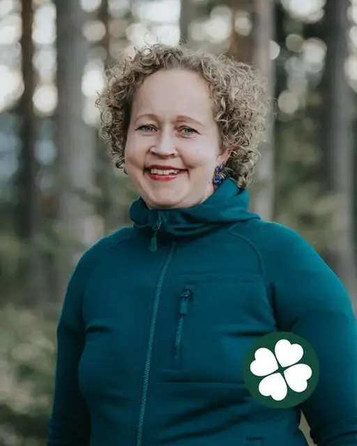 Hanna Lundberg leende i profil med tallar i bakgrunden och Centerklövern nere till höger i bild.