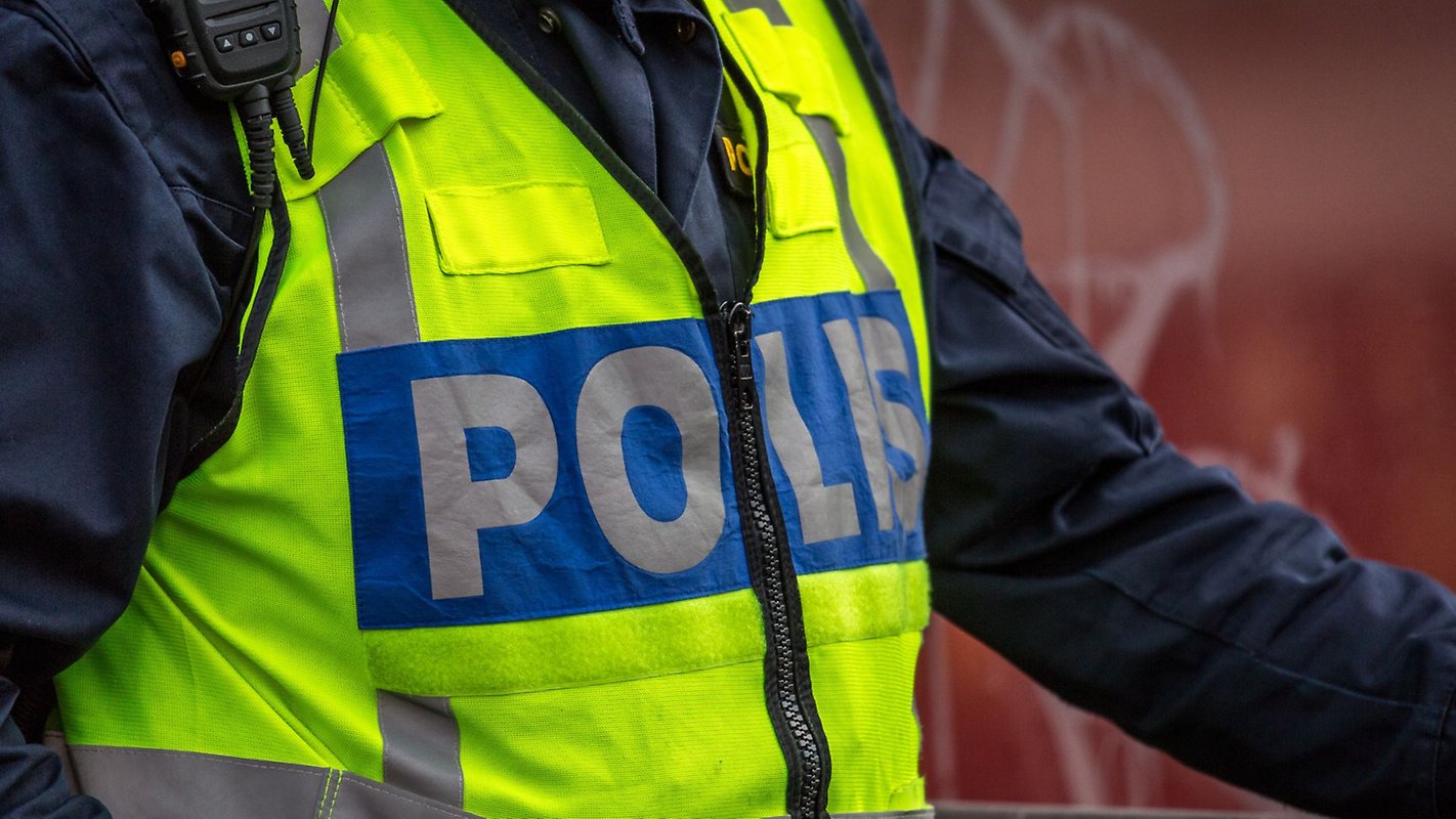Bild på en polis som står med en polisreflexväst